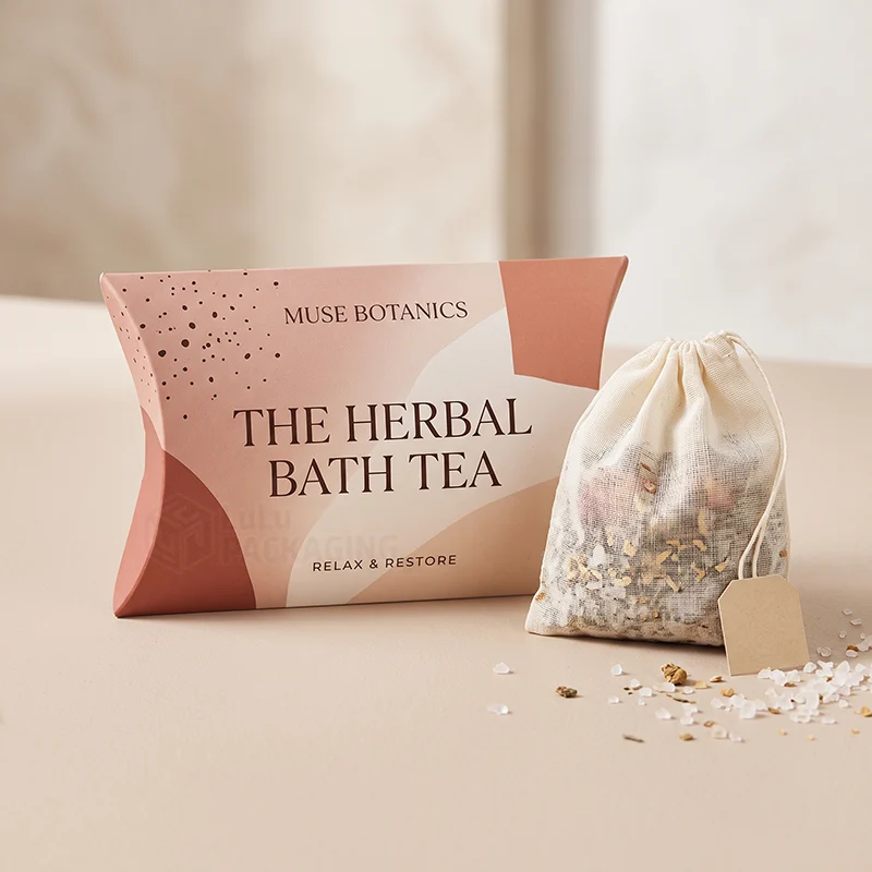 Pink printed bath tea pillow box next to a cotton soaking bag of herbs and salts