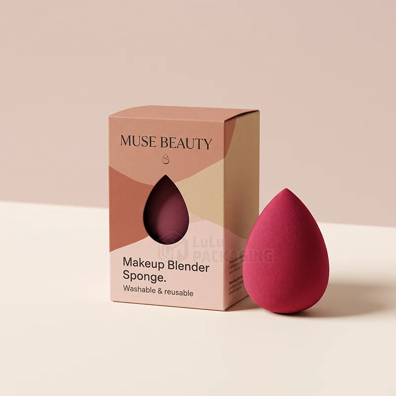 Printed makeup sponge box with a teardrop window beside a red blender sponge