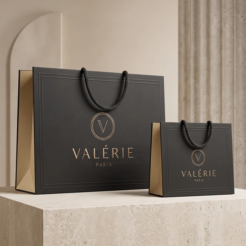 Two matte black luxury paper bags with braided rope handles and a rose gold foil logo