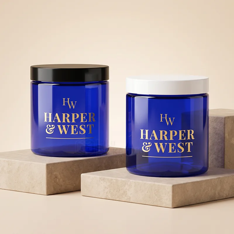 Two cobalt blue plastic cosmetic jars, one with a black lid and one with a white lid