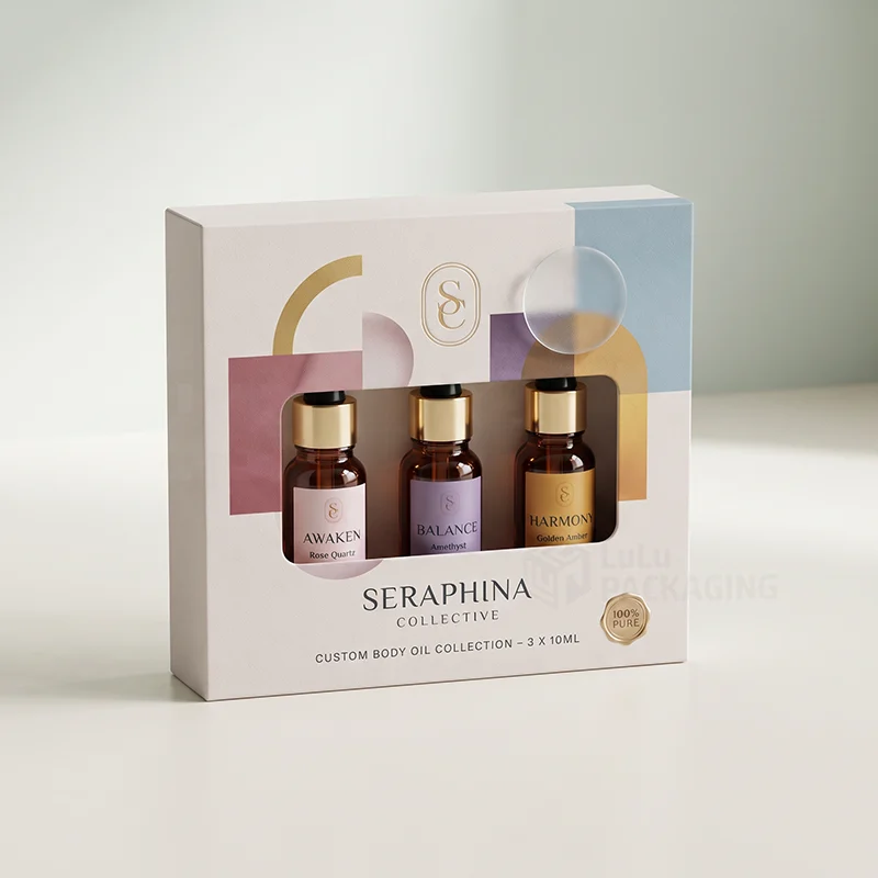 White body oil collection box with gold foil monogram and a window showing three bottles