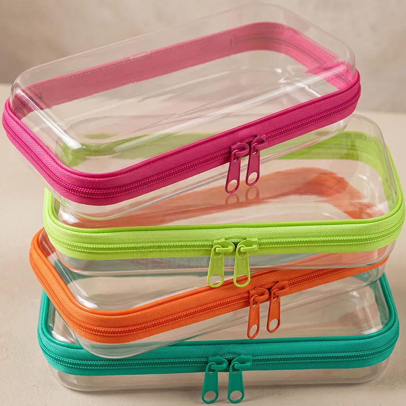 Stack of clear zipper pouches with pink, lime, orange and teal zippers