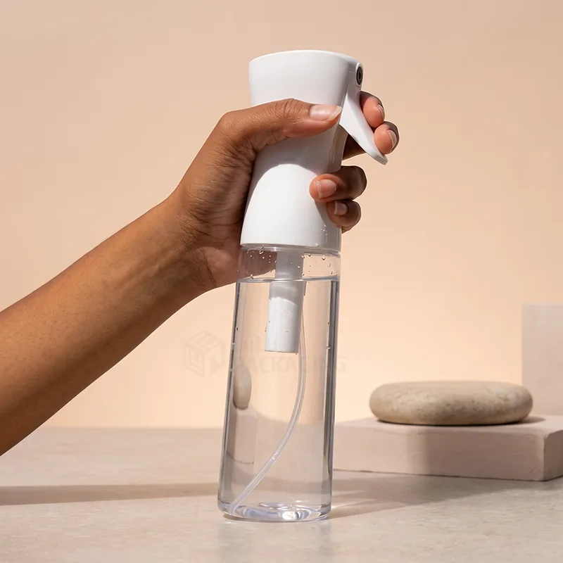 Hand holding a clear continuous fine mist spray bottle with a white trigger head