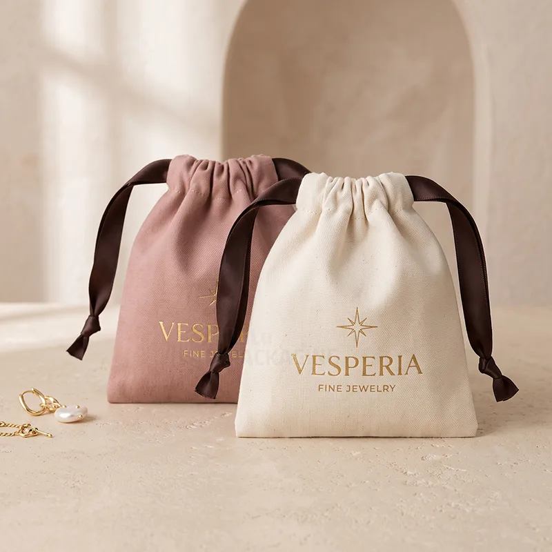 Pink and natural cotton pouches with brown satin ribbon drawstrings and a gold foil logo