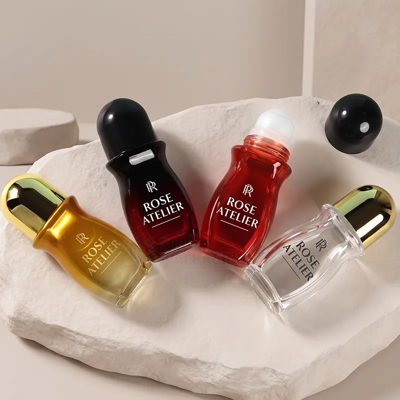 Curved roll-on bottles in gold, dark red, red and clear glass with dome caps