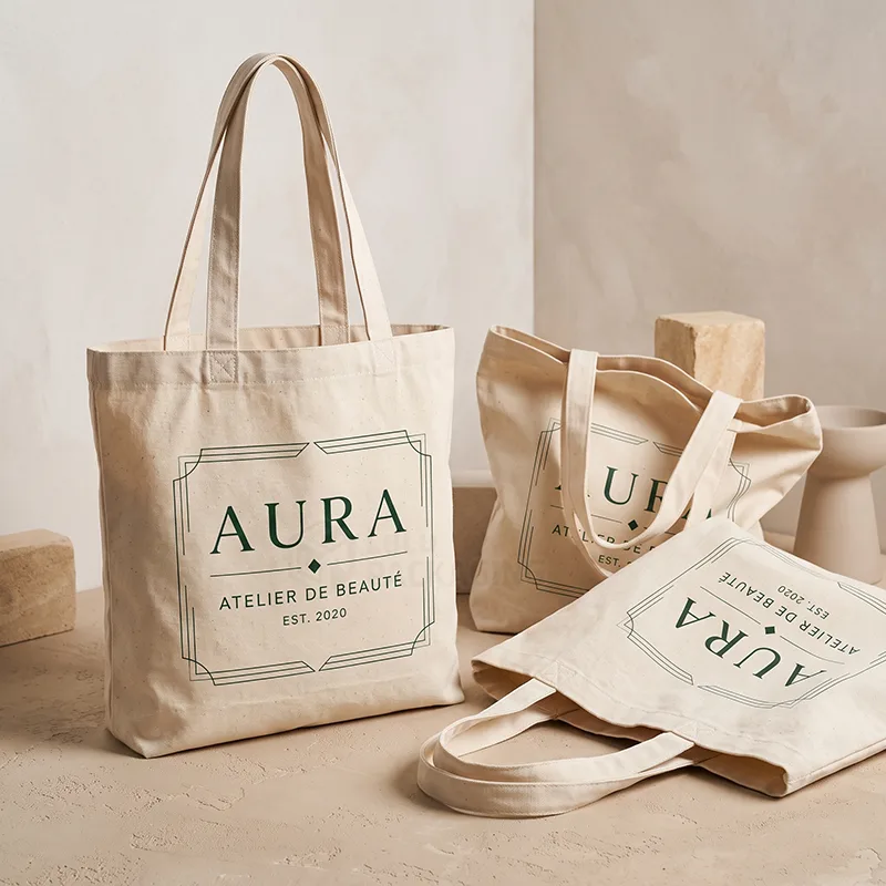 Natural cotton tote bags with a green printed logo, one standing and two lying flat