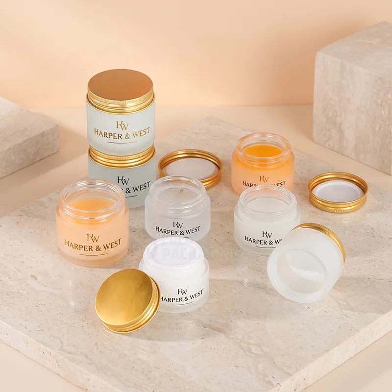 Frosted glass cream jars in white, clear and peach with gold metal lids and gold logos