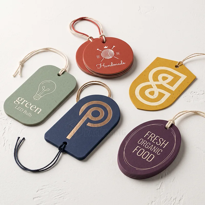 Five die-cut tags in arch, oval, round, rounded and shield shapes with foil logos and cotton strings