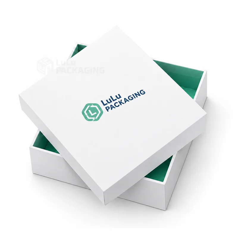 White two-piece gift box with a printed logo lid resting at an angle on its mint-lined base