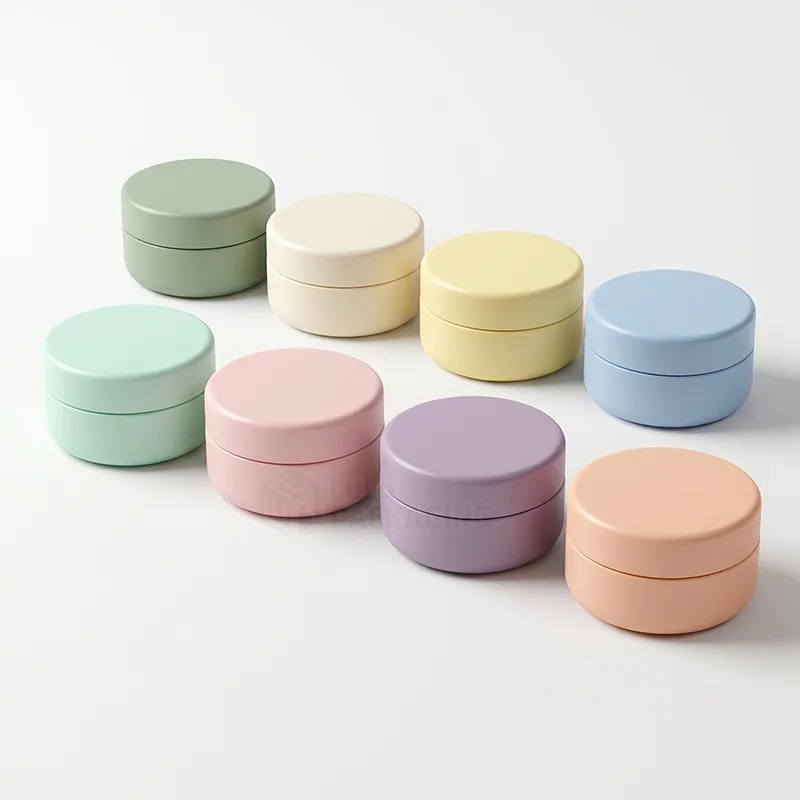 Two rows of small round lip balm pots with matching lids in pastel green, cream, yellow, blue, pink, lilac and peach