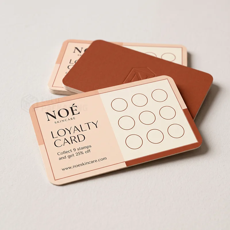 Rounded peach loyalty card with nine stamp circles, terracotta embossed card and spare stack behind