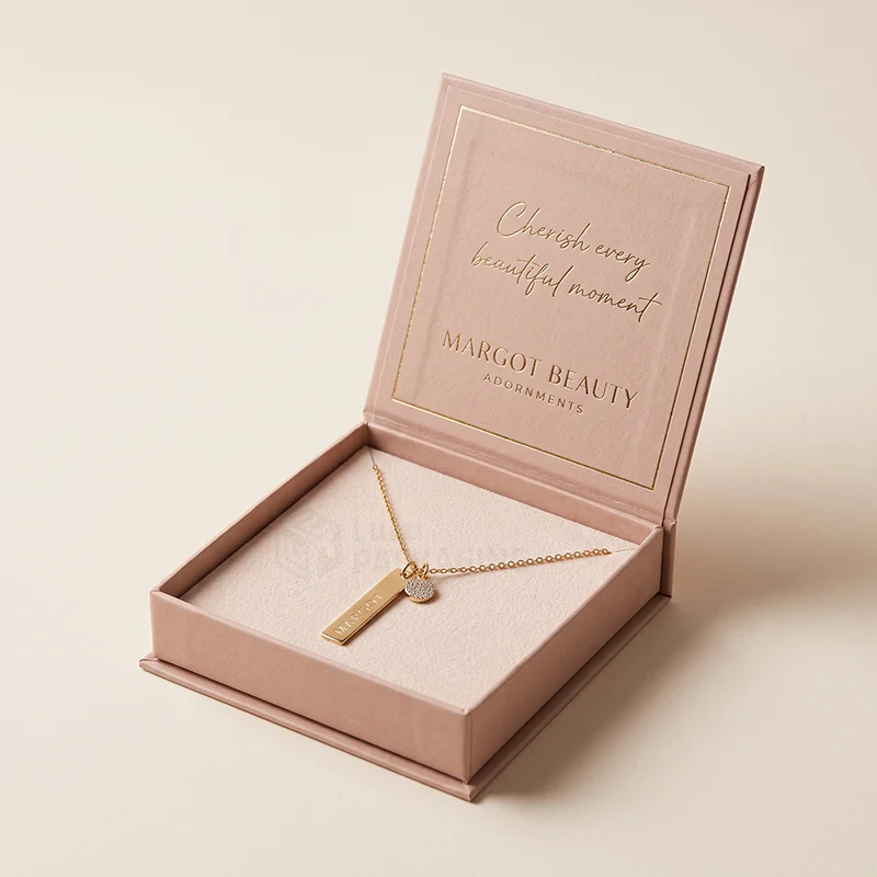 Blush magnetic necklace box open to show a gold bar pendant necklace on a cream insert
