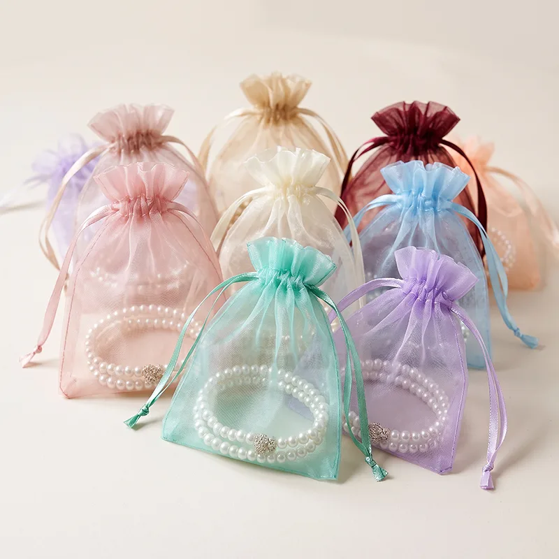 Organza drawstring bags in pastel colours with pearl bracelets showing through