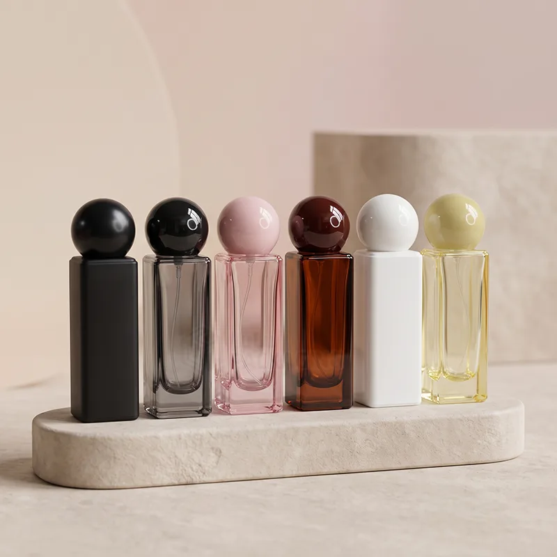 Six square perfume bottles in black, smoke, pink, amber, white and yellow with round ball caps