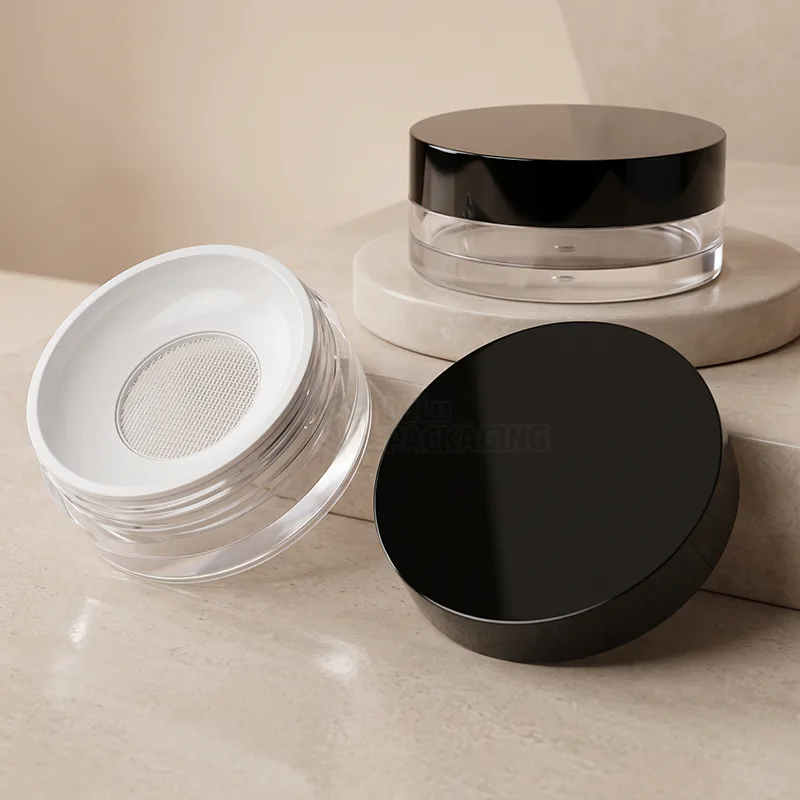 Clear loose powder jars with black lids, one open showing the mesh sifter