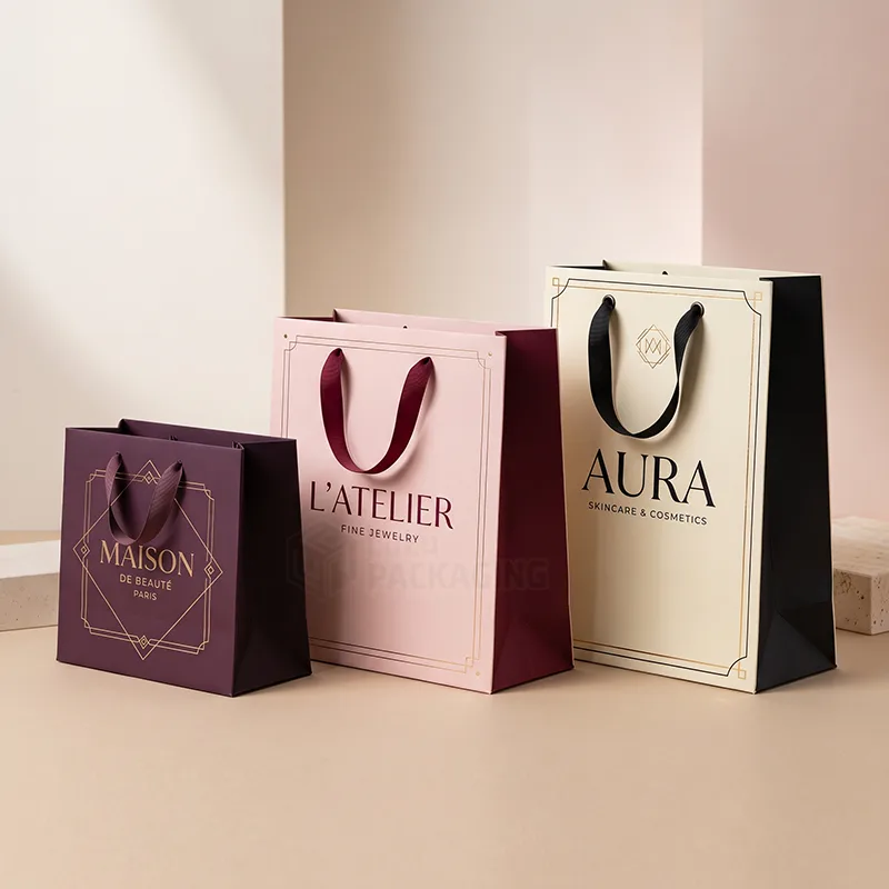 Purple, pink and cream paper retail bags in three sizes with ribbon handles and printed logos