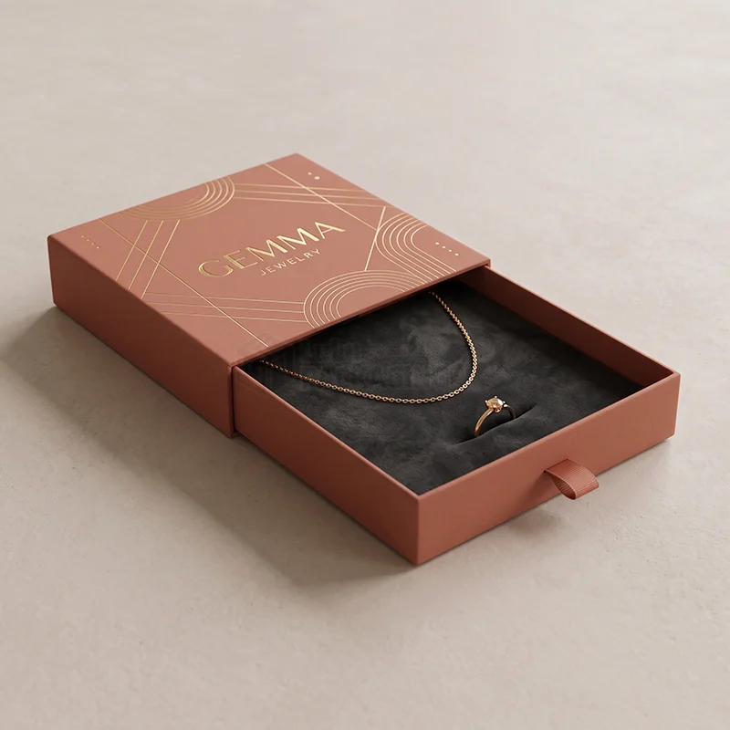 Terracotta drawer jewellery box with a gold foil sleeve, open to show a necklace and ring