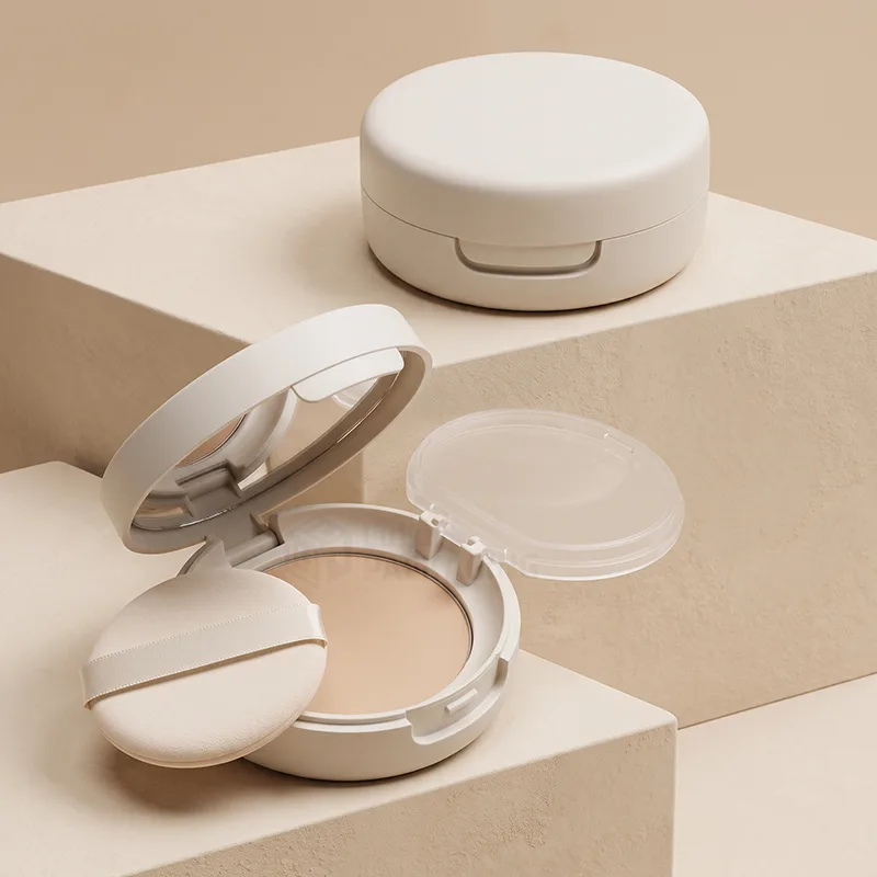 Round cream compact case open showing the mirror, pressed powder and a puff