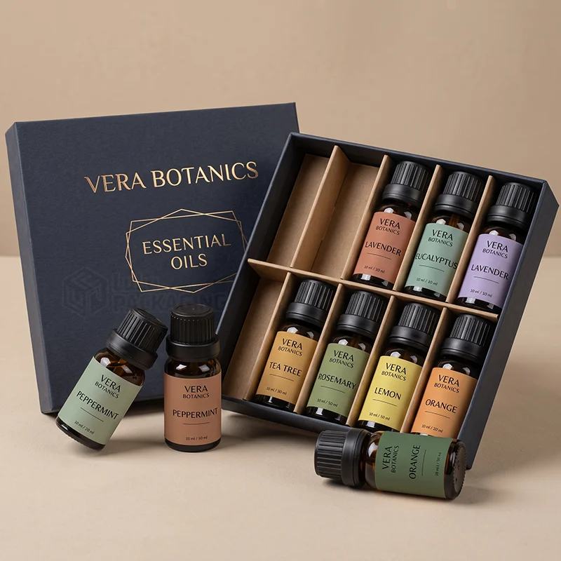 Navy rigid essential oil gift box with gold foil logo and kraft dividers holding amber bottles