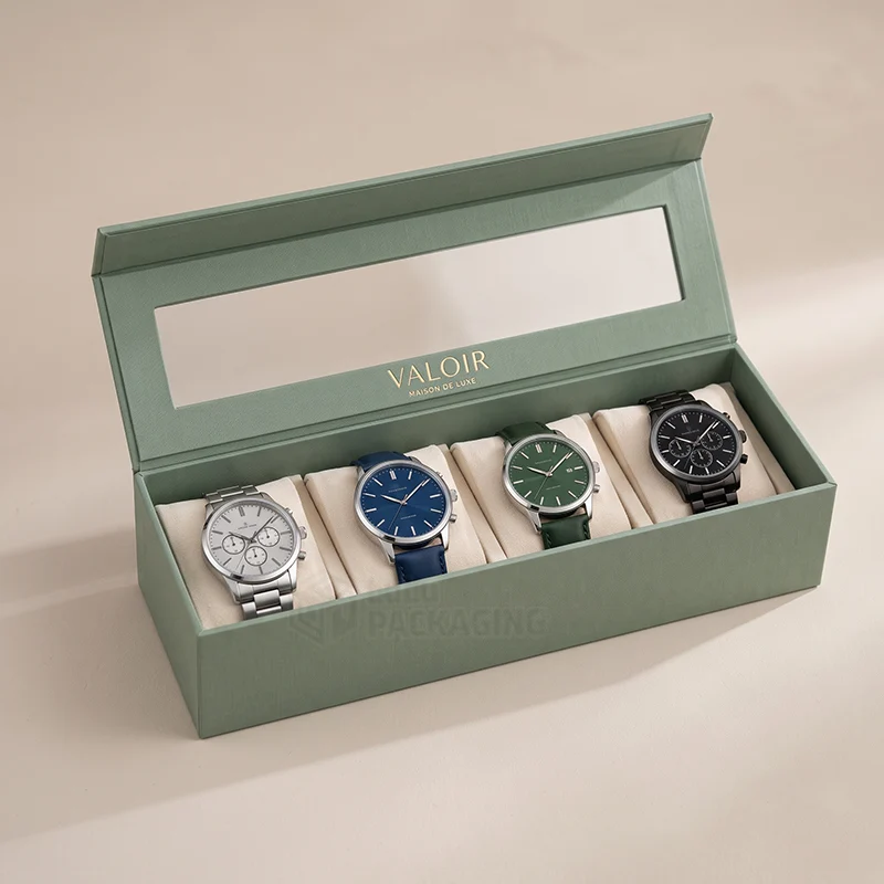 Sage green magnetic watch box with a clear window lid holding four chronograph watches