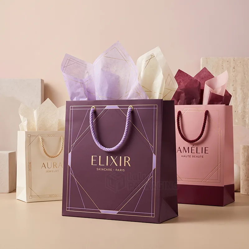 Purple, cream and pink gift bags with twisted rope handles filled with patterned tissue paper