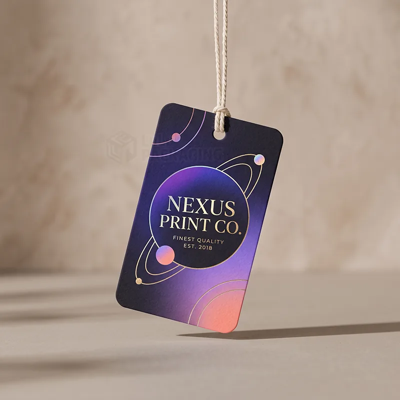 Purple gradient hang tag with gold foil rings and small iridescent planets, hanging on a cotton string
