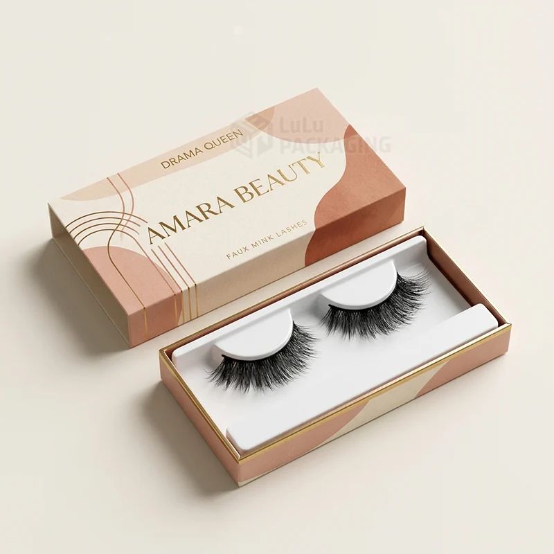 Peach sleeve box with gold foil slid open to show lashes on a white tray
