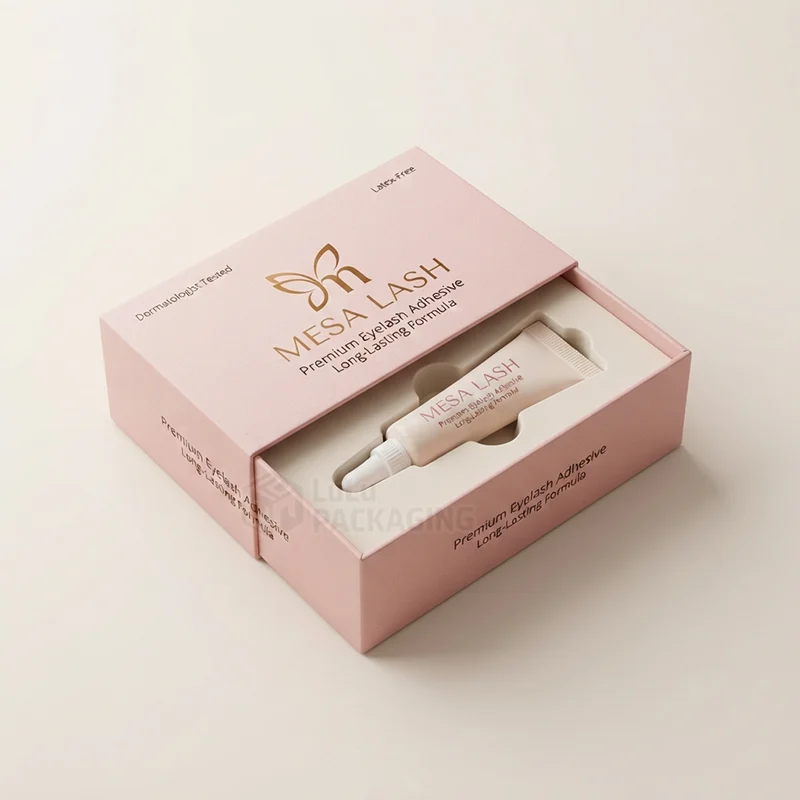 Pink sleeve box with gold foil logo slid open to show a glue tube in a cut-out insert