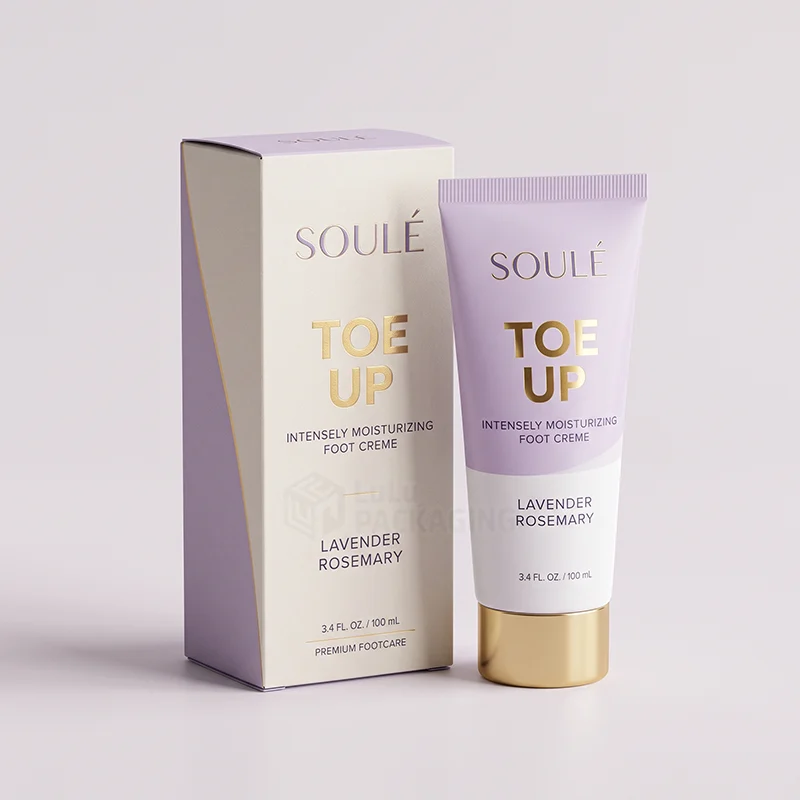 Cream and lilac foot cream box with gold foil lettering beside a matching tube