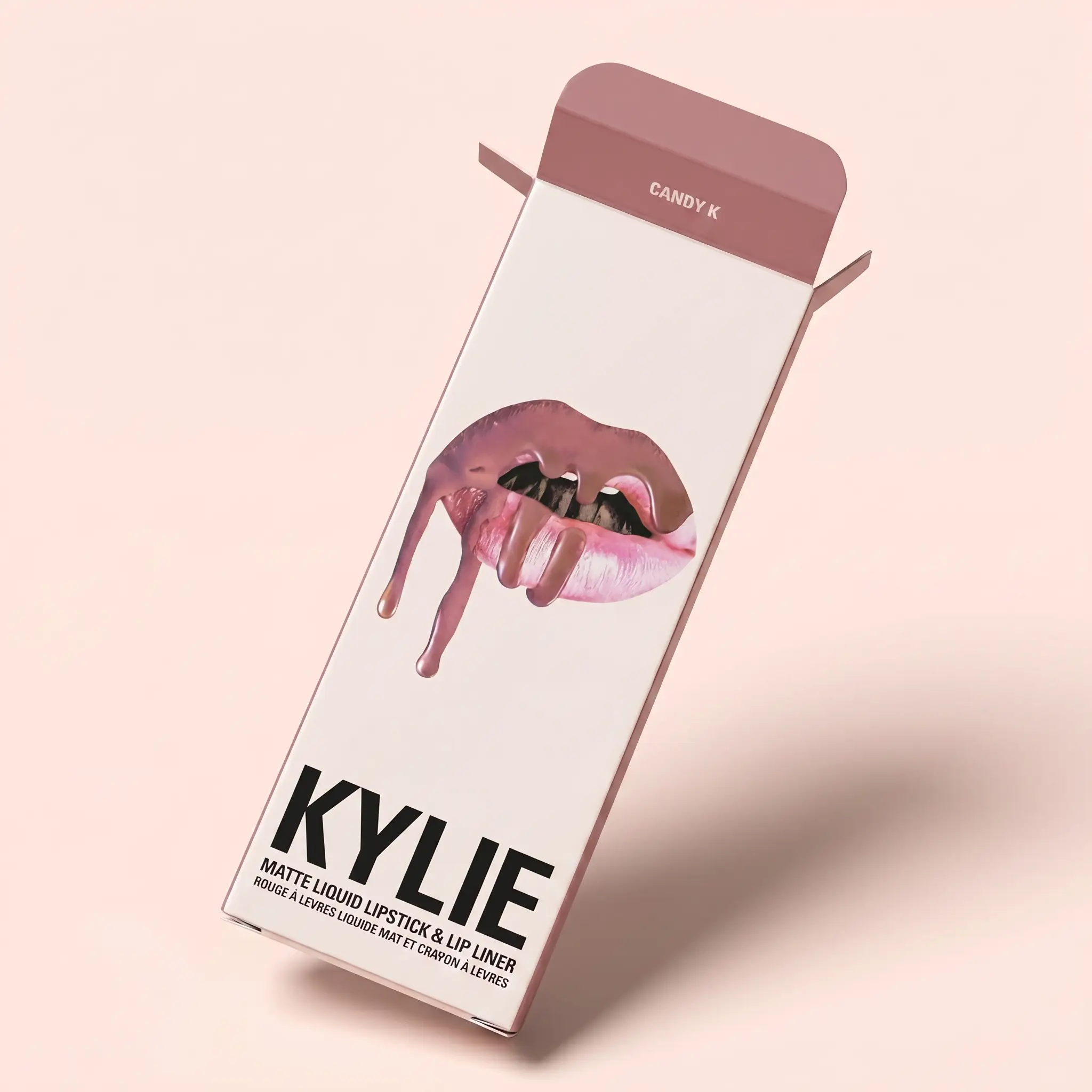 Tall lip liner box with matching gradient lip product beside it on a soft pink background.