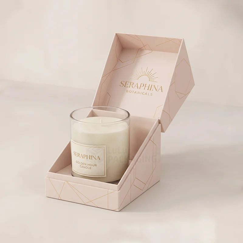 Blush pink hinged rigid candle box with gold foil logo holding a glass jar candle