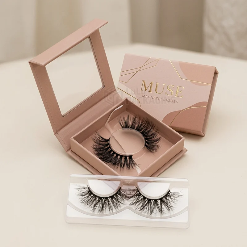 Pink magnetic lash box with a mirror lid open to show lashes beside a sleeve and tray