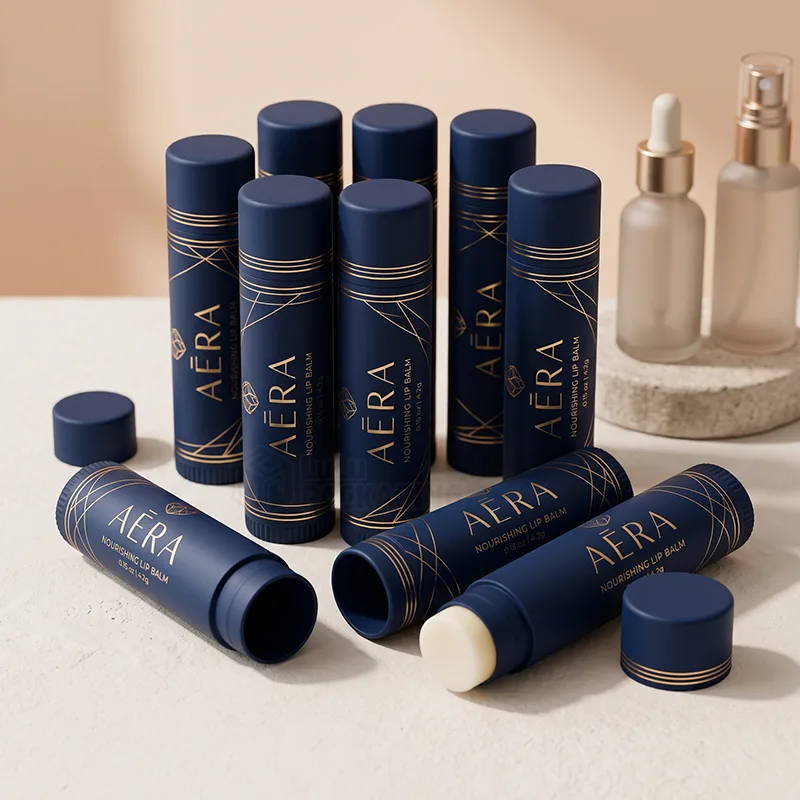 Navy blue lip balm tubes with gold line printing, some open showing the balm