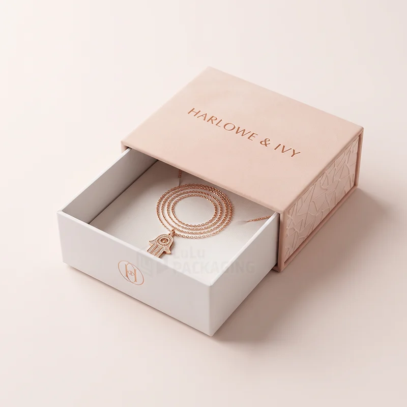 Pink and white drawer necklace box with a rose gold foil logo and a coiled pendant chain