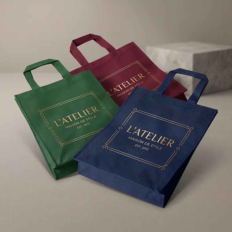 Three non woven tote bags in green, burgundy and navy with gold foil framed logos