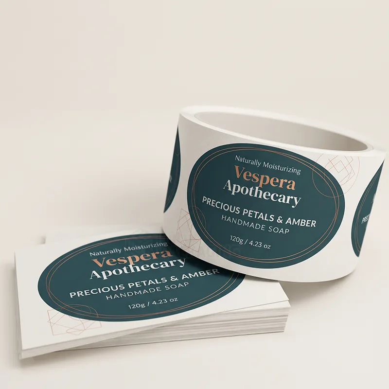 Roll and stack of dark teal oval handmade soap labels with copper text