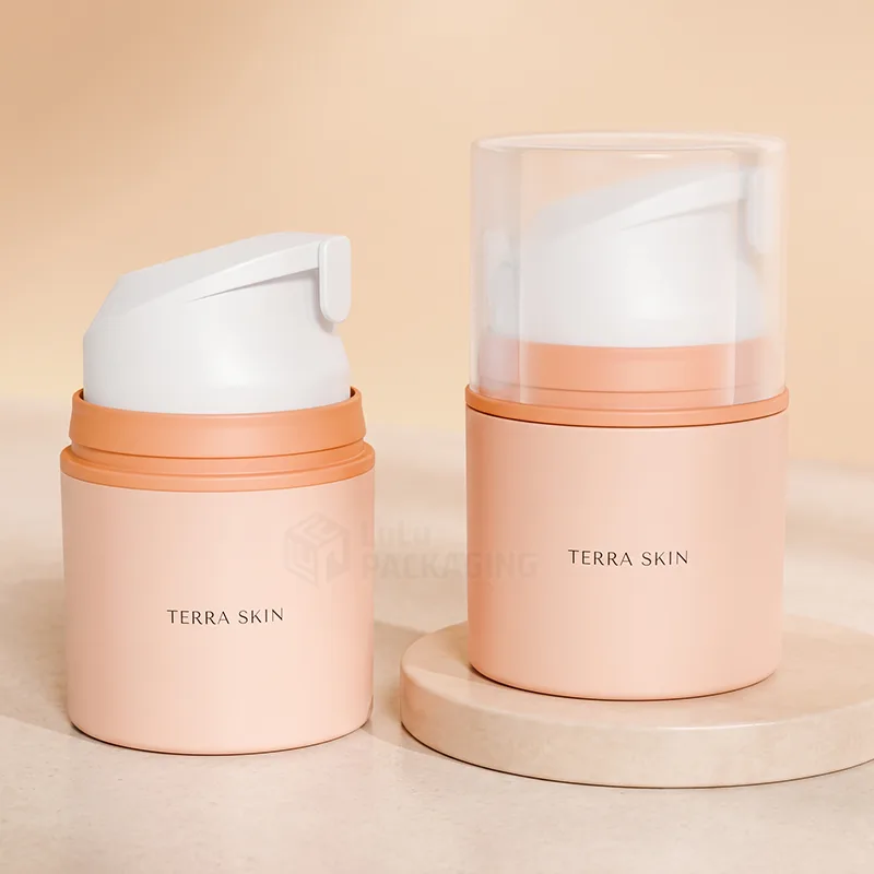 Two short peach airless pump bottles with white pump heads, one with a clear overcap