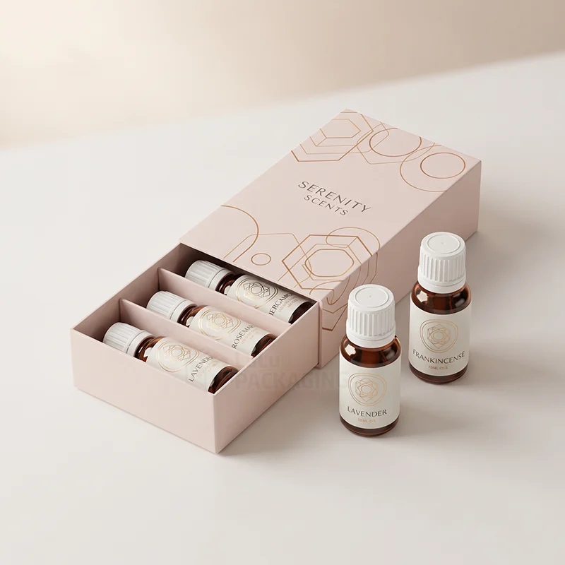 Blush pink aromatherapy drawer box with copper foil and amber oil bottles in divided slots