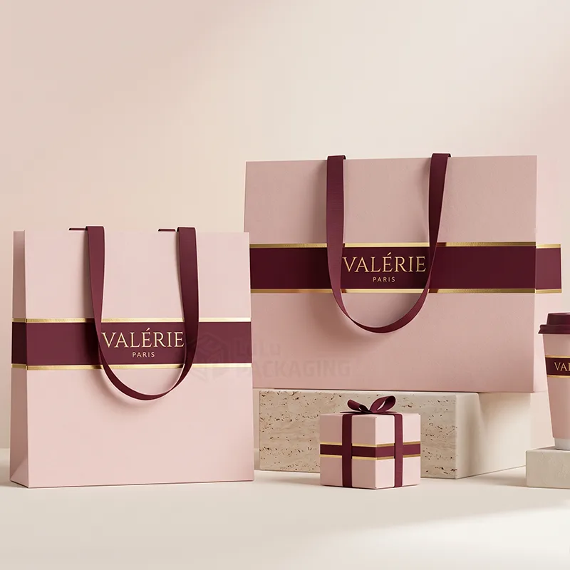 Pink boutique bags with a burgundy and gold foil band, ribbon handles and a matching gift box