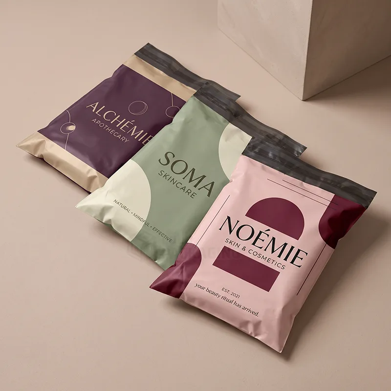 Three printed poly mailers in plum, sage and pink with adhesive seal strips