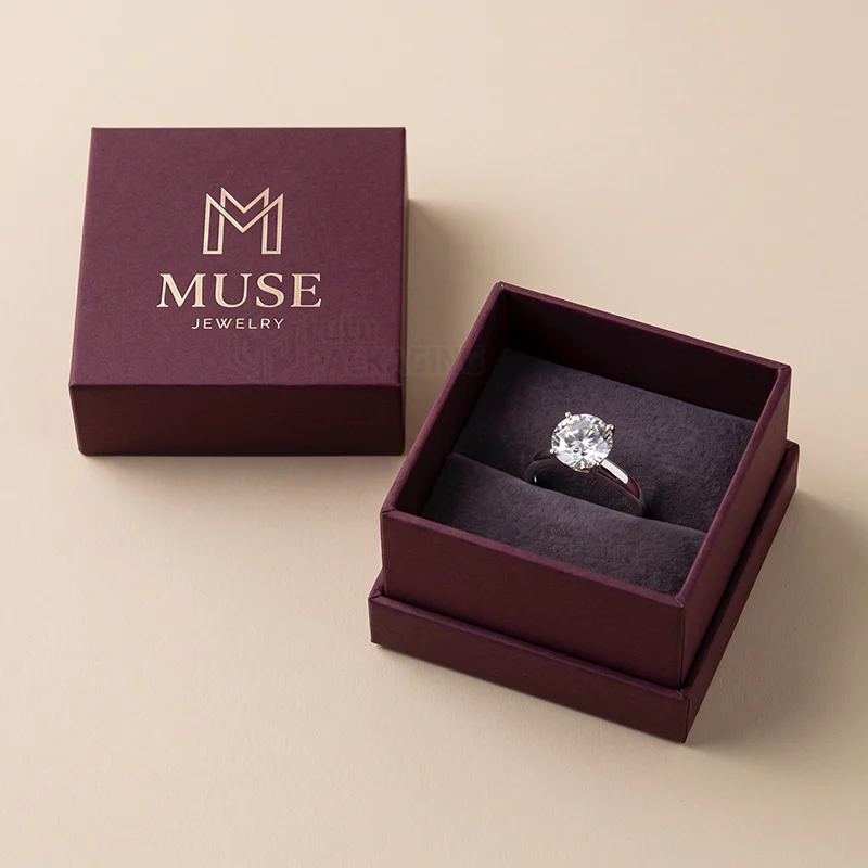 Burgundy two-piece ring box with the lid off, showing a diamond ring in a grey velvet slot