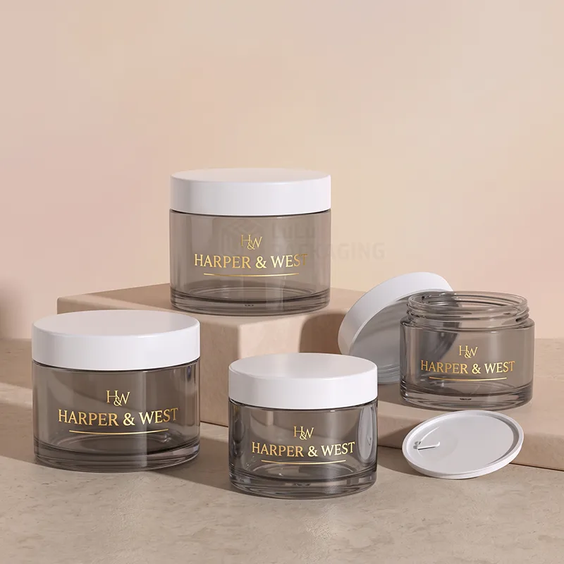 Smoky grey cream jars with white lids and gold foil logos in different sizes