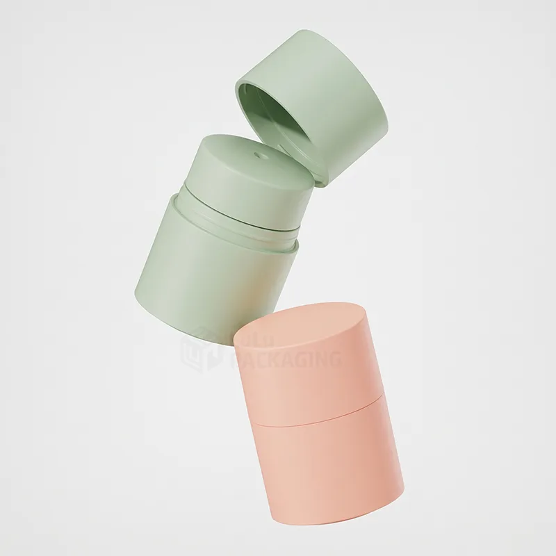 Two tall matte cylindrical pots in sage green and peach, the green one with its lid lifted off