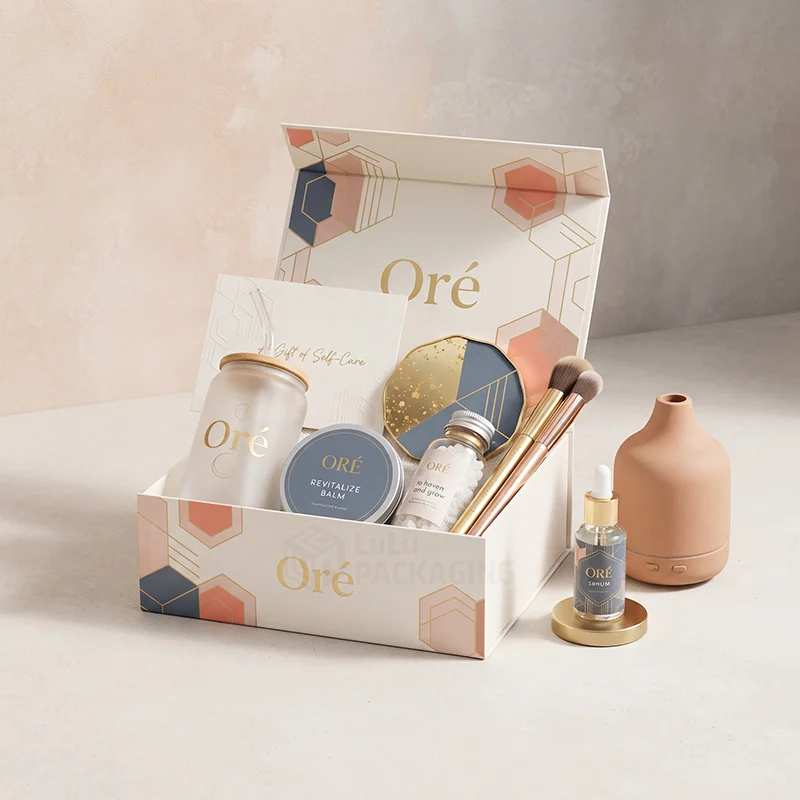 White magnetic self care gift box with gold foil logo holding a tumbler, balm and brushes